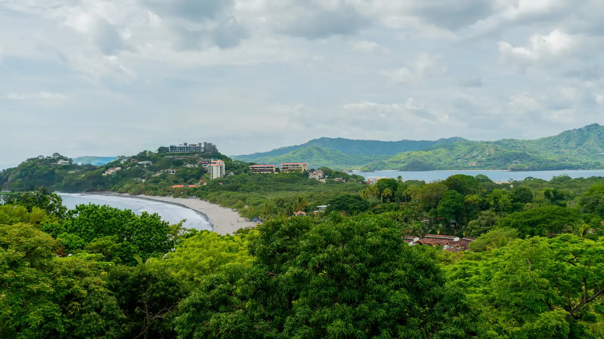 Flamingo headland with white sand curve and hillside estates